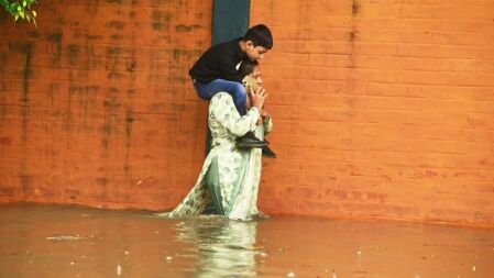 জলাবদ্ধতায় কোমর পানিতে মায়ের কাঁধে শিশু ছবি ভাইরাল
