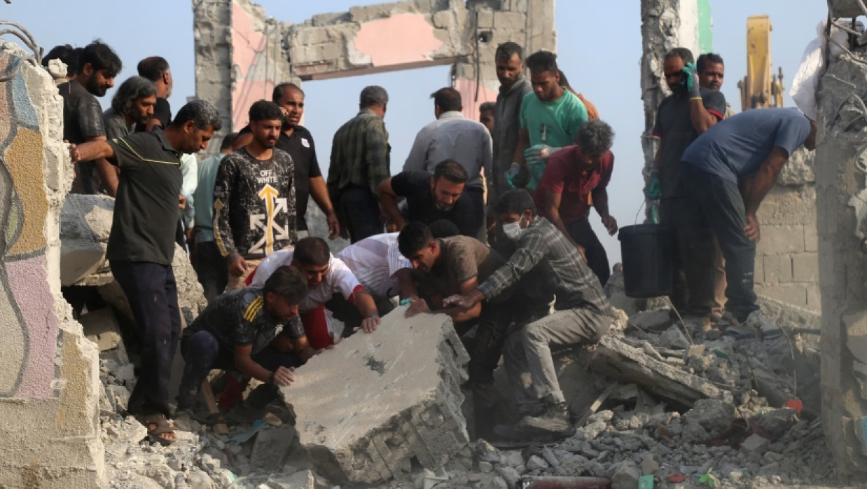 Rescue workers and residents search through the rubble in the aftermath of an Israeli-U.S. strike on a girls' elementary school in Minab