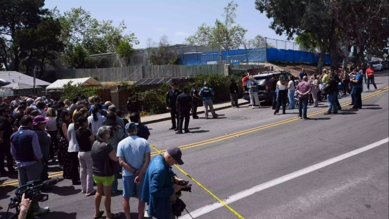 A crowd gathers near the scene of a shooting outside the Islamic Center of San Diego Monday, May 18, 2026, in San Diego