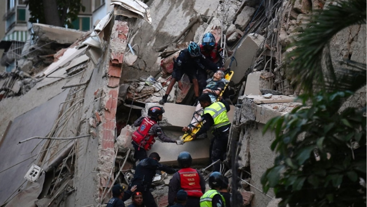 Rescue workers carry a person on a stretcher out of a collapsed building after a magnitude 7.2 earthquake struck Caracas, Venezuela