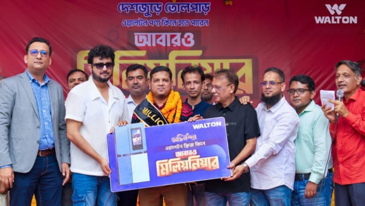 সৌভাগ্যবান ক্রেতা আশরাফুল ইসলামকে ১০ লাখ টাকা হস্তান্তর করছেন চিত্রনায়ক আমিন খানসহ ওয়ালটনের ঊর্দ্ধতন কর্মকর্তাগণ