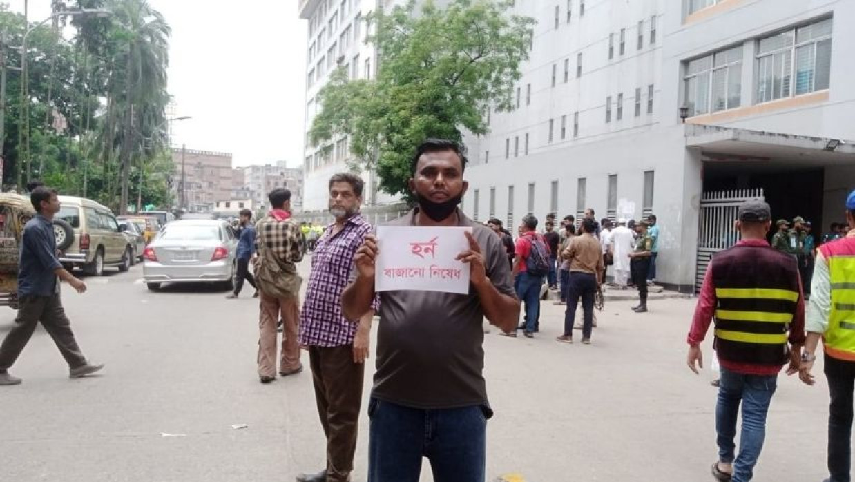 সৌদী আরব প্রবাসী উমর ফারুক প্লেকেড নিয়ে দাঁড়ানো