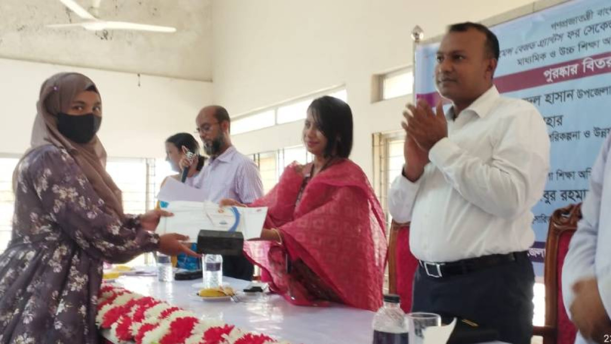 কৃতী শিক্ষার্থীকে ক্রেস্ট ও সার্টিফিকেট তুল দেওয়া হচ্ছে