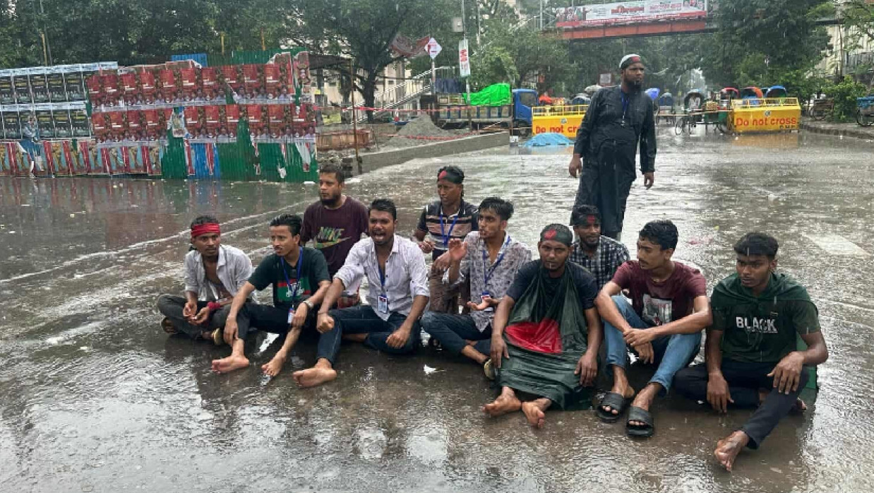 বৃষ্টিতে সড়কে বসে বিভিন্ন স্লোগান দিচ্ছেন আন্দোলনকারীরা