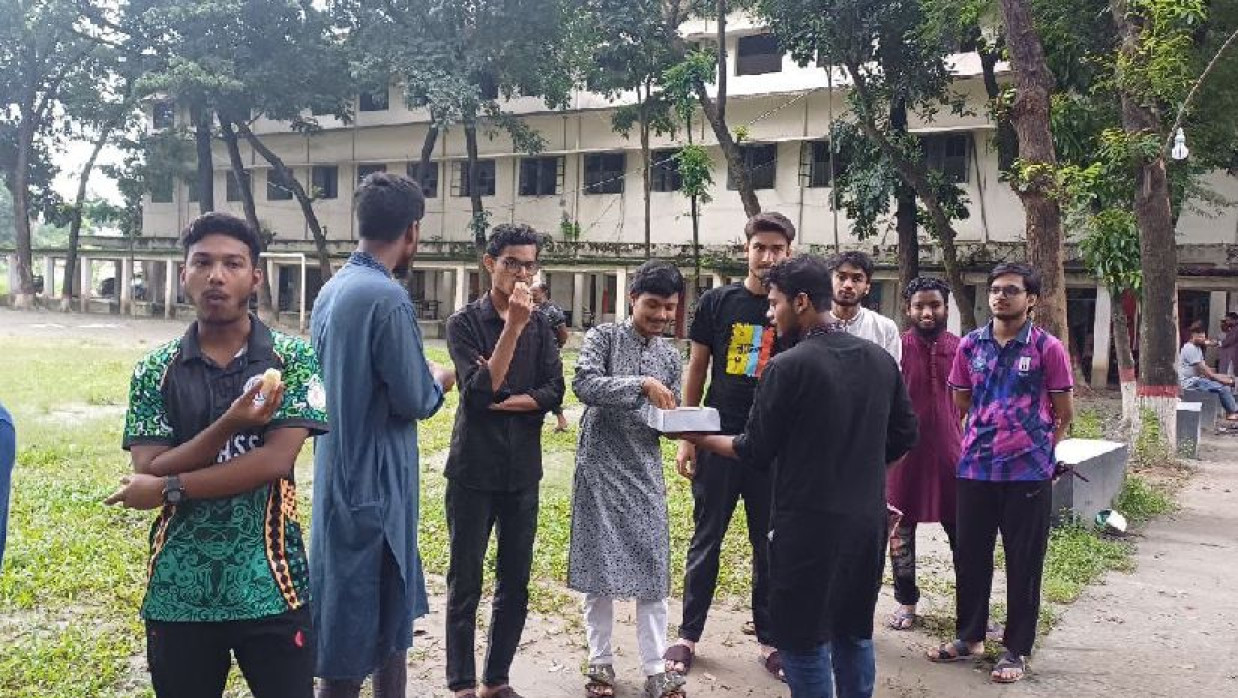 মিষ্টি বিতরণ করছে শিক্ষার্থীরা