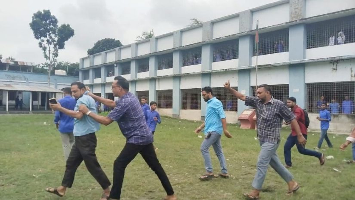 স্কুল-শিক্ষককে শার্টের কলার চেপে নিয়ে যাওয়া হচ্ছে