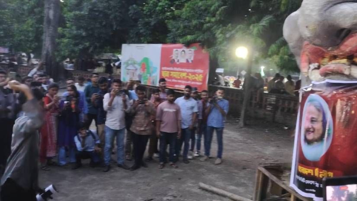 শেখ হাসিনার ছবির ওপর ডিম নিক্ষেপ করছেন একজন