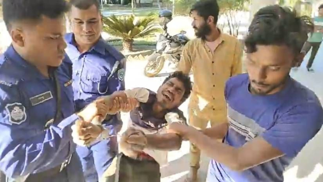 যুবককে গ্রেপ্তার করে নিয়ে যাচ্ছে পুলিশ
