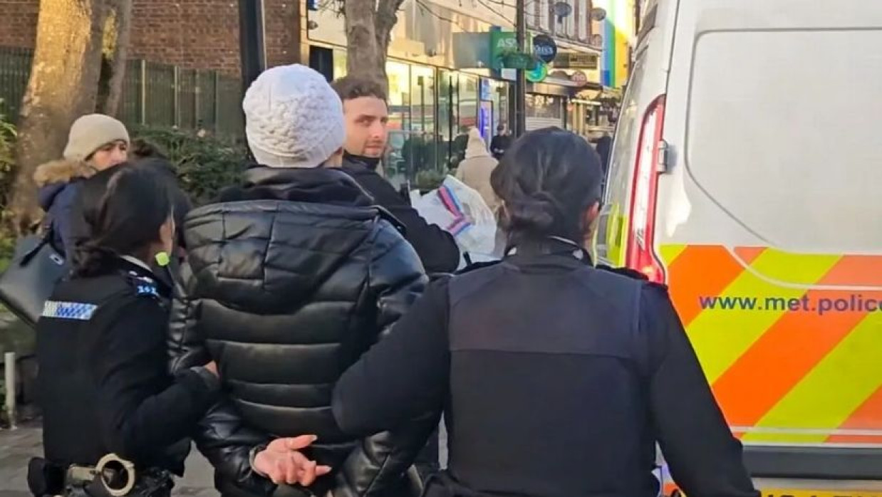 নারীকে হাতকড়া পরিয়ে আটক করেছে পুলিশ