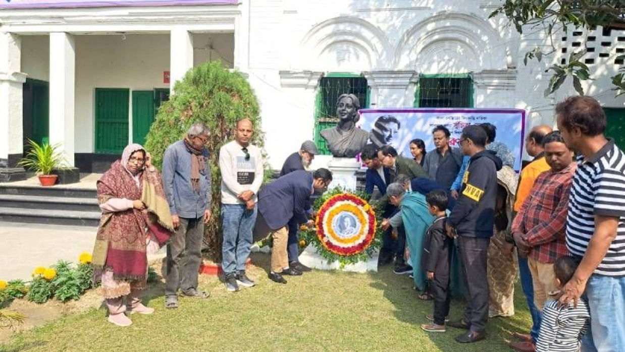 সুচিত্রা সেনের প্রতিকৃতিতে পুষ্পস্তবক অর্পণ করা হচ্ছে