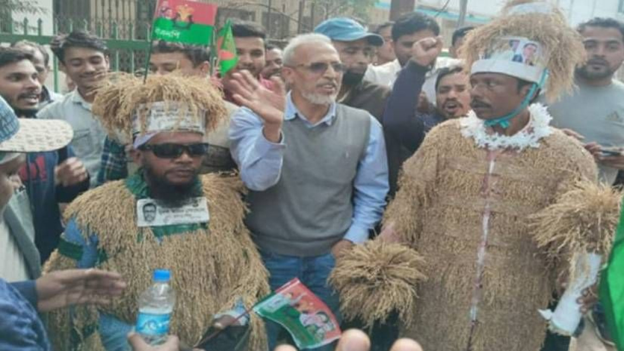 বিএনপির সমাবেশস্থলে ধানের পোশাক পরে আসা নেপাল চন্দ্র দাশ ও সাইদুল ইসলাম