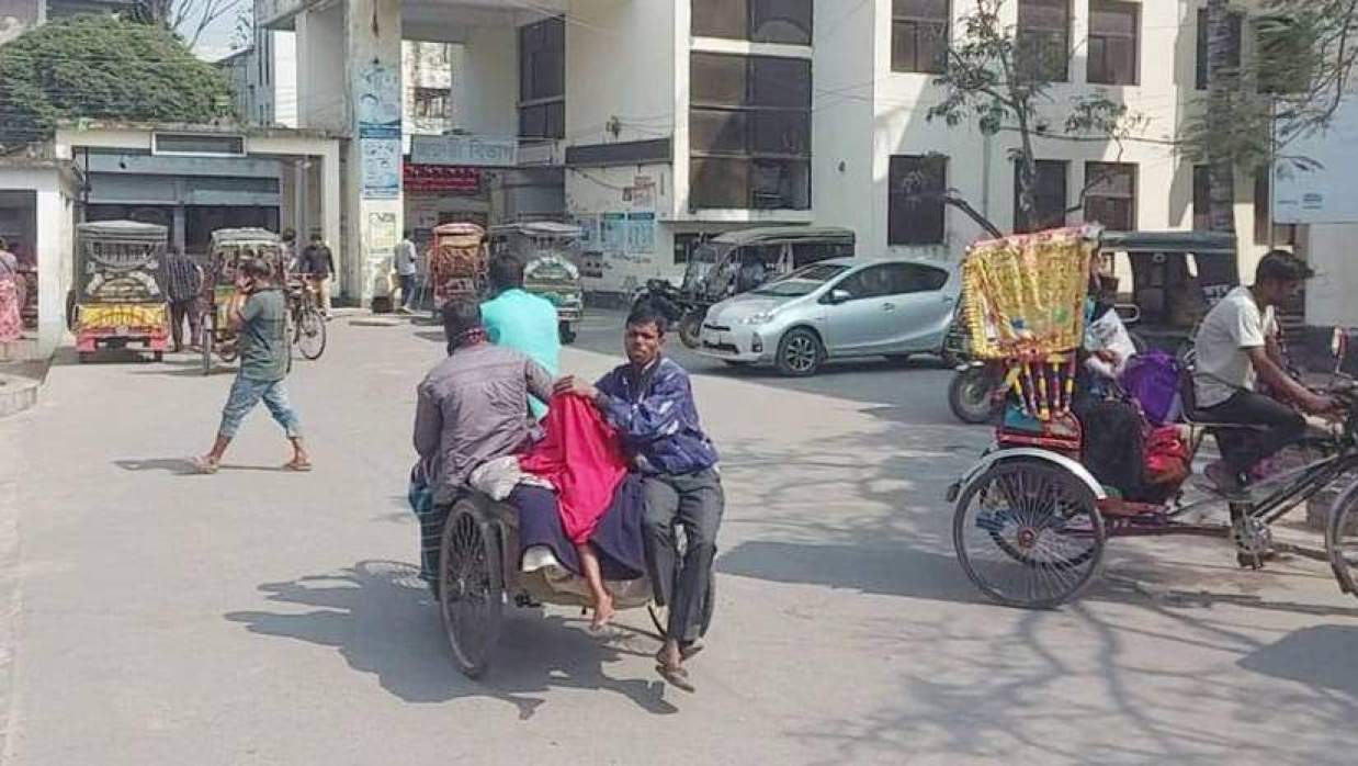 আহত একজনকে ভ্যানে করে হাসপাতালে নেওয়া হচ্ছে