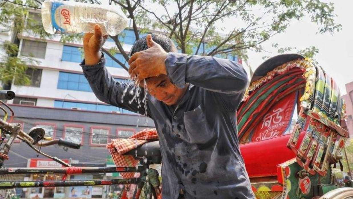 গরমে মাথায় পানি ঢালছেন রিকশাচালক