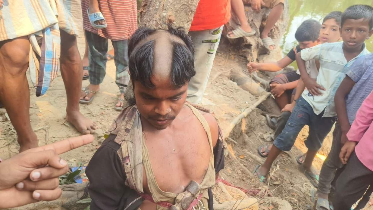 মাথা ন্যাড়া করার পর যুবককে গাছের সঙ্গে বেঁধে রাখা হয়