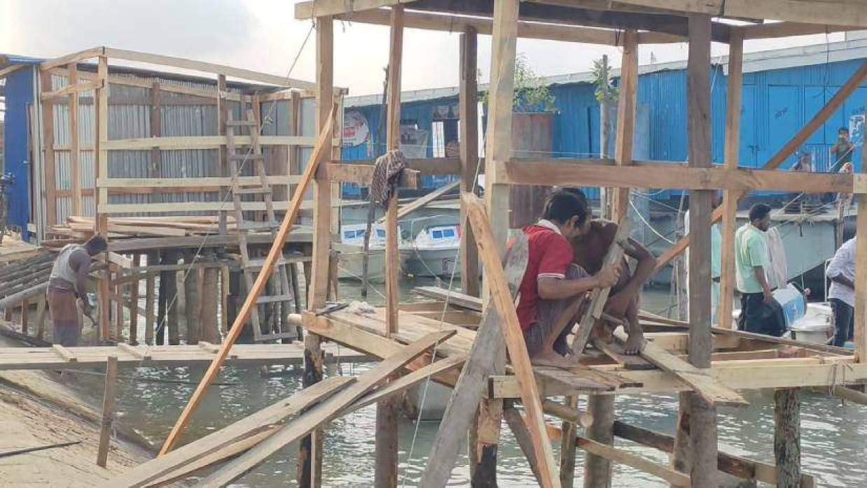 ধুলিয়া লঞ্চঘাটের পাশে নদীতীরে দোকানঘরের নির্মাণকাজ চলছে