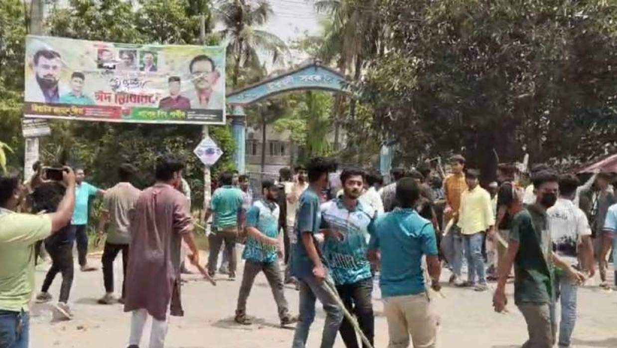 ঈশ্বরদী সরকারি কলেজের প্রধান ফটকের সামনে লাঠিসোঁটা হাতে কয়েকজন