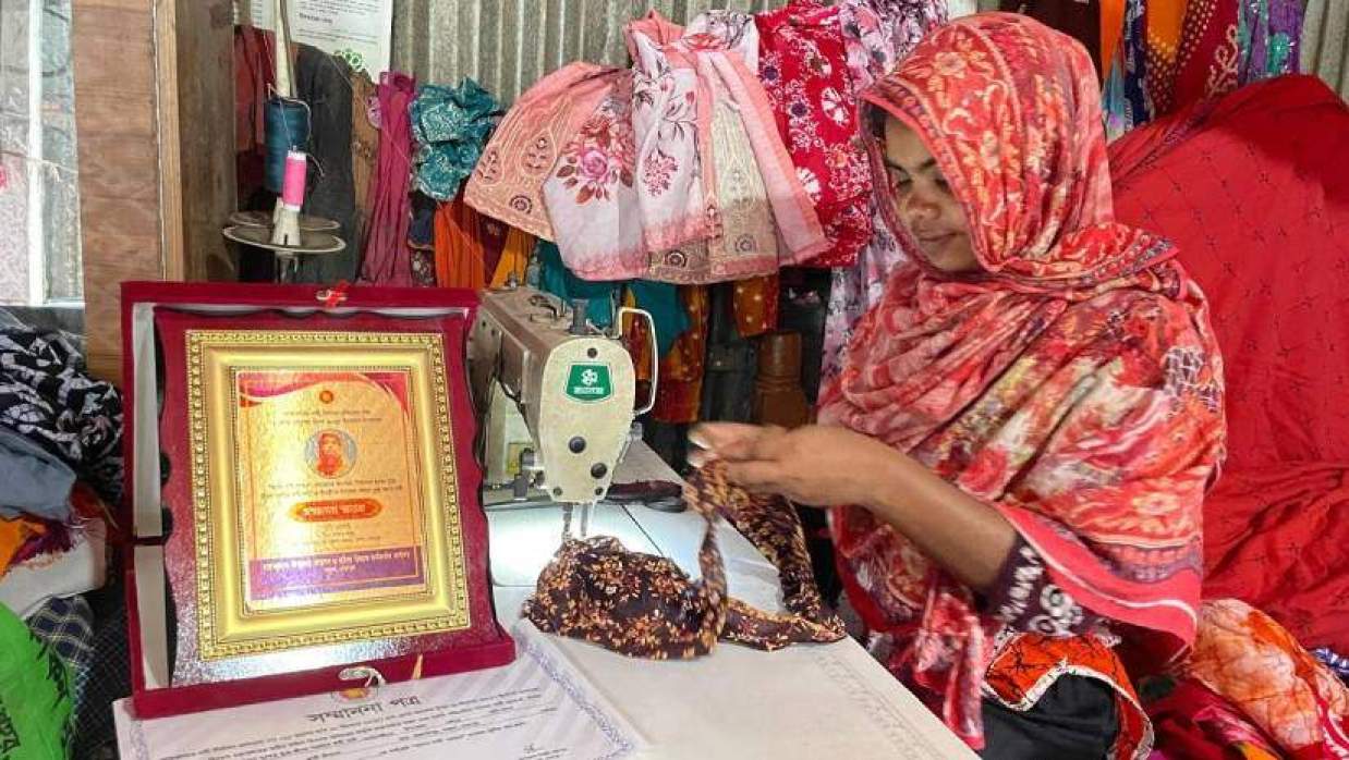 সেলাই মেশিনে কাজ করছেন সুমী বেগম