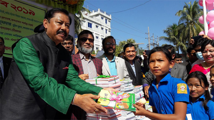শিক্ষার্থীদের হাতে বই তুলে দিচ্ছেন বীর বাহাদুর 