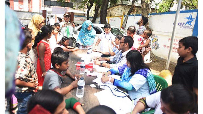 আয়োজক প্যানেল শিশুদের মাঝে ফ্রি স্বাস্থ সেবা দিচ্ছেন।