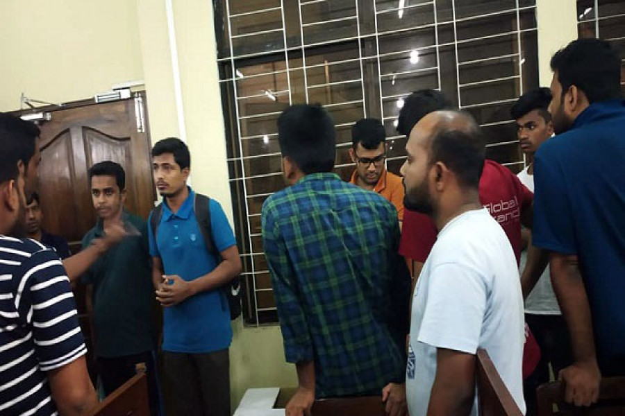 আটককৃত বহিরাগতদের (বামে) হল অফিসে জিজ্ঞাসাবাদ করা হয়