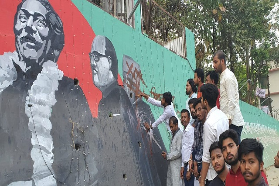 মুক্তিযোদ্ধার সন্তানদের একটি সংগঠনের সদস্য ও ছাত্রলীগের নেতাকর্মীরা মোশতাকের ছবি মুছে দিচ্ছেন