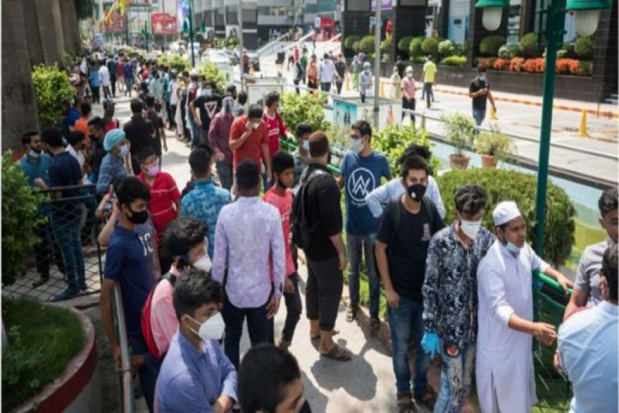 করোনা পরিস্থিতির মধ্যে ঢাকার একটি শপিং মলে  ঢোকার জন্য তরুণদের লম্বা লাইন