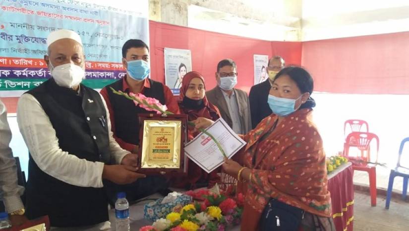 প্রধান অতিথির হাত থেকে সম্মাননা গ্রহণ করছেন এক ‘জয়িতা’