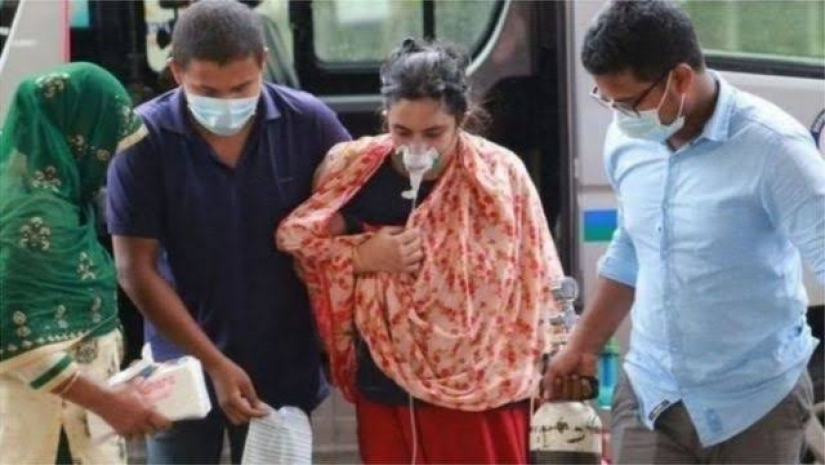 করোনায় আক্রান্ত এক নারীকে হাসপাতালে নেয়া হচ্ছে