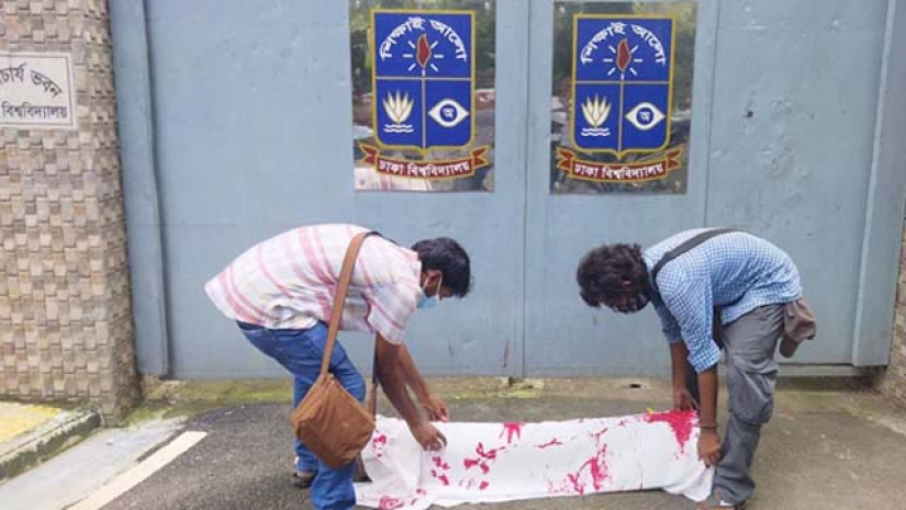 শিক্ষার্থীরা গাছের কফিন সম্বলিত গাছের গুঁড়িটি উপাচার্যের বাসভবনের ফটকের সামনে রাখছেন