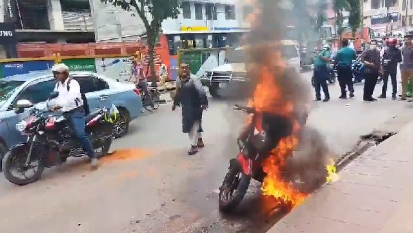 পুড়তে থাকা বাইকের পাশে দাঁড়িয়ে পাঠাও চালক শওকত, একটু দূরে পুলিশ