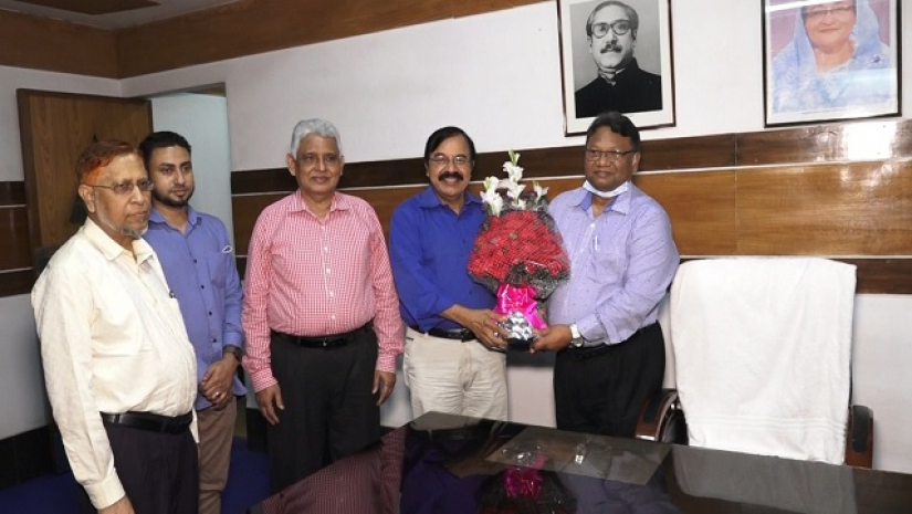 নতুন অধ্যক্ষকে ফুল দিয়ে বরণ করে নিচ্ছেন 