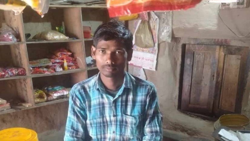 নিজের মুদি দোকানে বসে আছেন দীপক