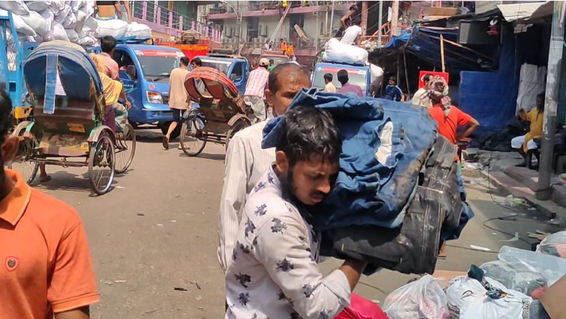 পোড়া-ভেজা কাপড় সরিয়ে নিচ্ছেন ব্যবসায়ীরা 