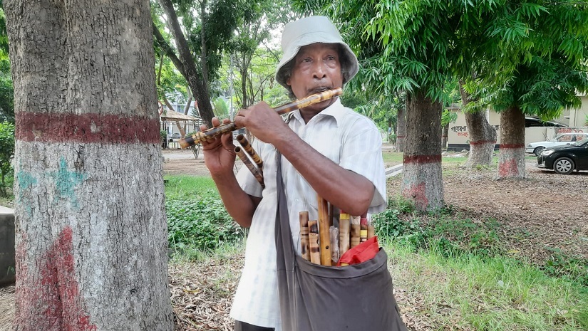 রাবি ক্যাম্পাসে বাঁশি বিক্রেতা গনেশ চন্দ্র দাস