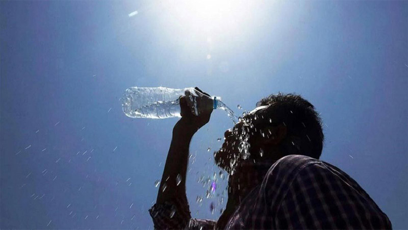 গরম থেকে বাঁচতে ‍মুখে পানি ঢালছেন এক ব্যক্তি