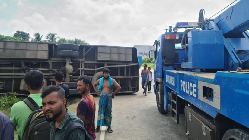 নিয়ন্ত্রণ হারিয়ে একটি যাত্রীবাহী বাস উল্টে সড়কে পড়ে আছে
