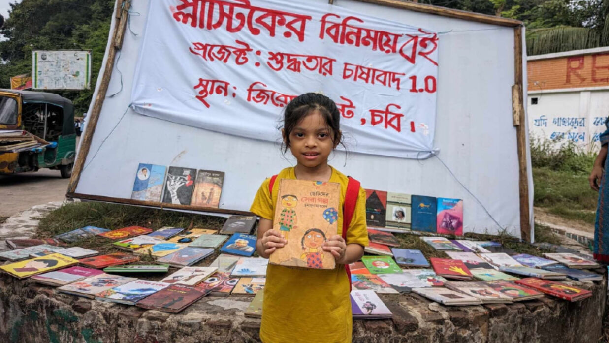 প্লাস্টিকের বিনিময়ে একটি বই পেয়েছে এই শিশুটি
