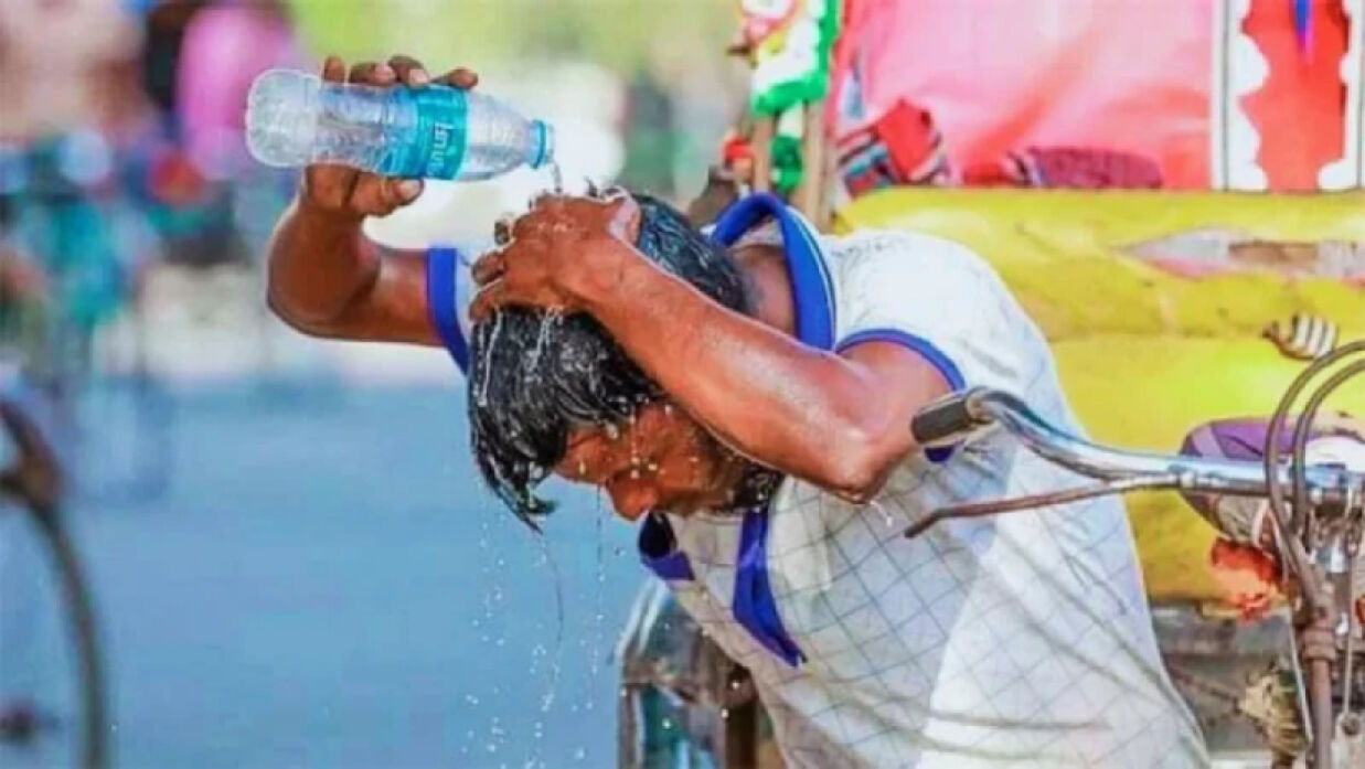হিট অ্যালার্ট থেকে বাঁচতে মাথায় পানি ঢালছেন এক ব্যক্তি