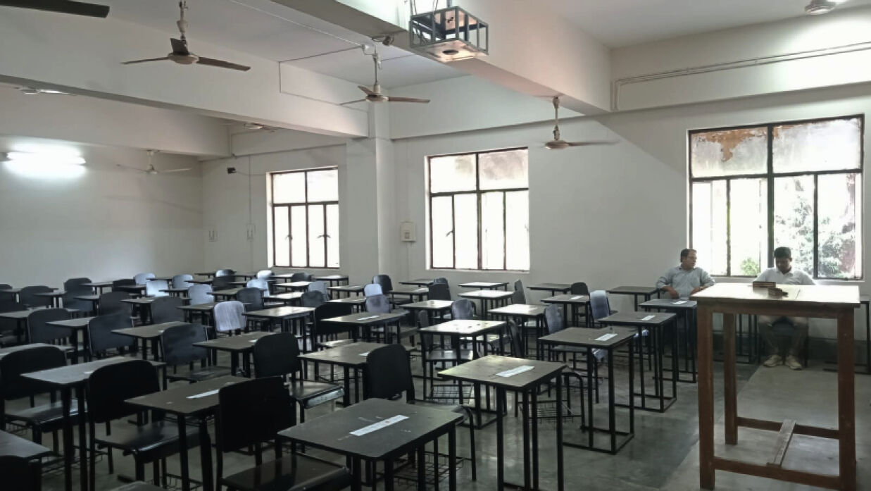 পরীক্ষা গ্রহণের জন্য শ্রেণিকক্ষে অপেক্ষা করছেন এক শিক্ষক ও কর্মকর্তা। দুপুরে বুয়েট থেকে তোলা।