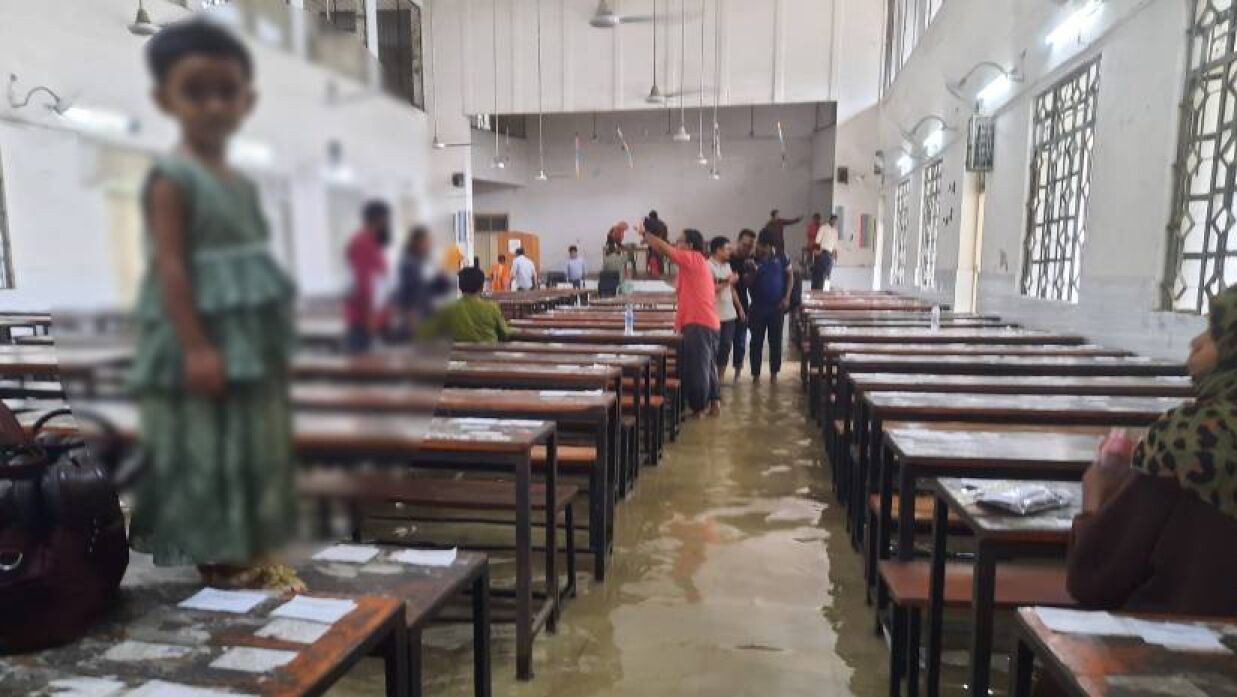 পরীক্ষার কেন্দ্রে পানি। কন্যাকে বেঞ্চে দাঁড় করিয়ে পরীক্ষায় বসলেন মা। ধানমণ্ডি বয়েজ হাইস্কুল কেন্দ্রের ছবি