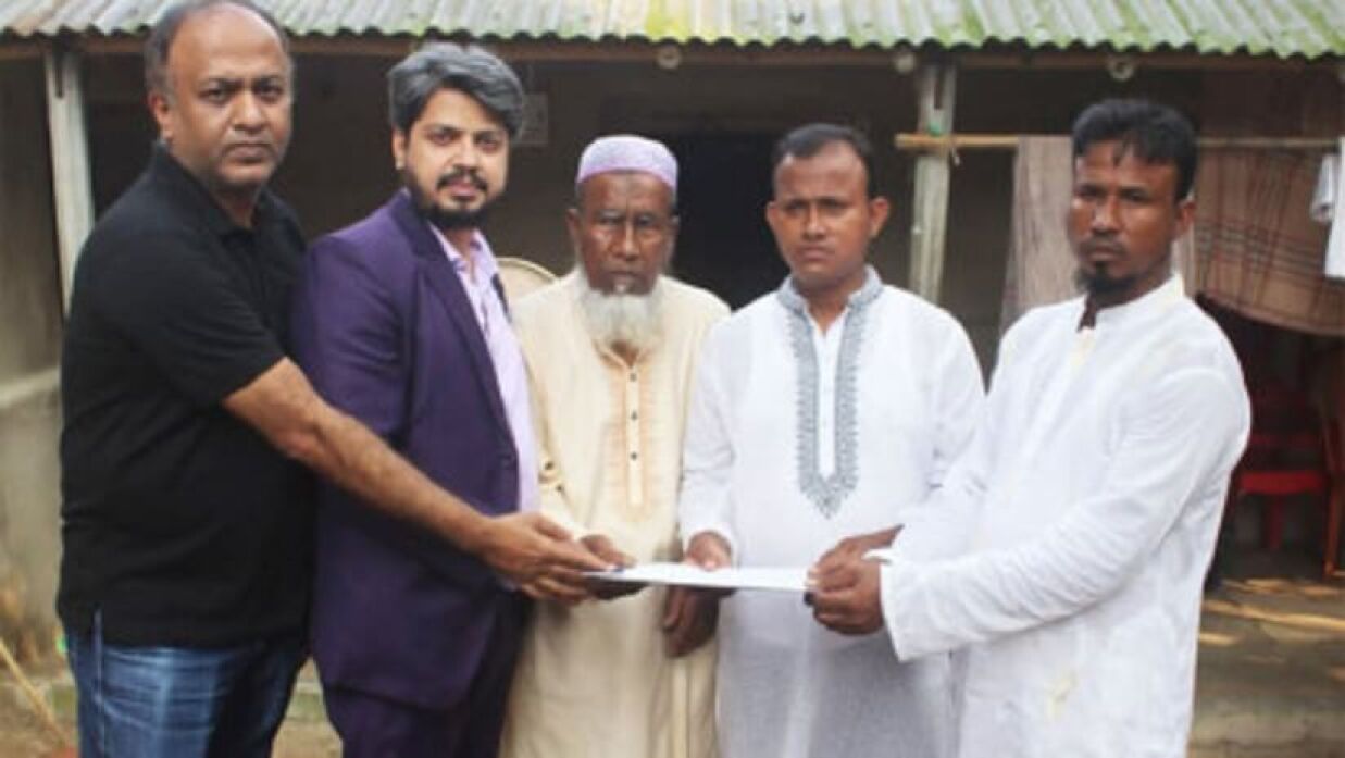 আবু সাঈদের গ্রামের বাড়িতে তার দুই ভাই আবু হোসেন ও রমজান আলীর হাতে নিয়োগপত্র তুলে দেওয়া হচ্ছে