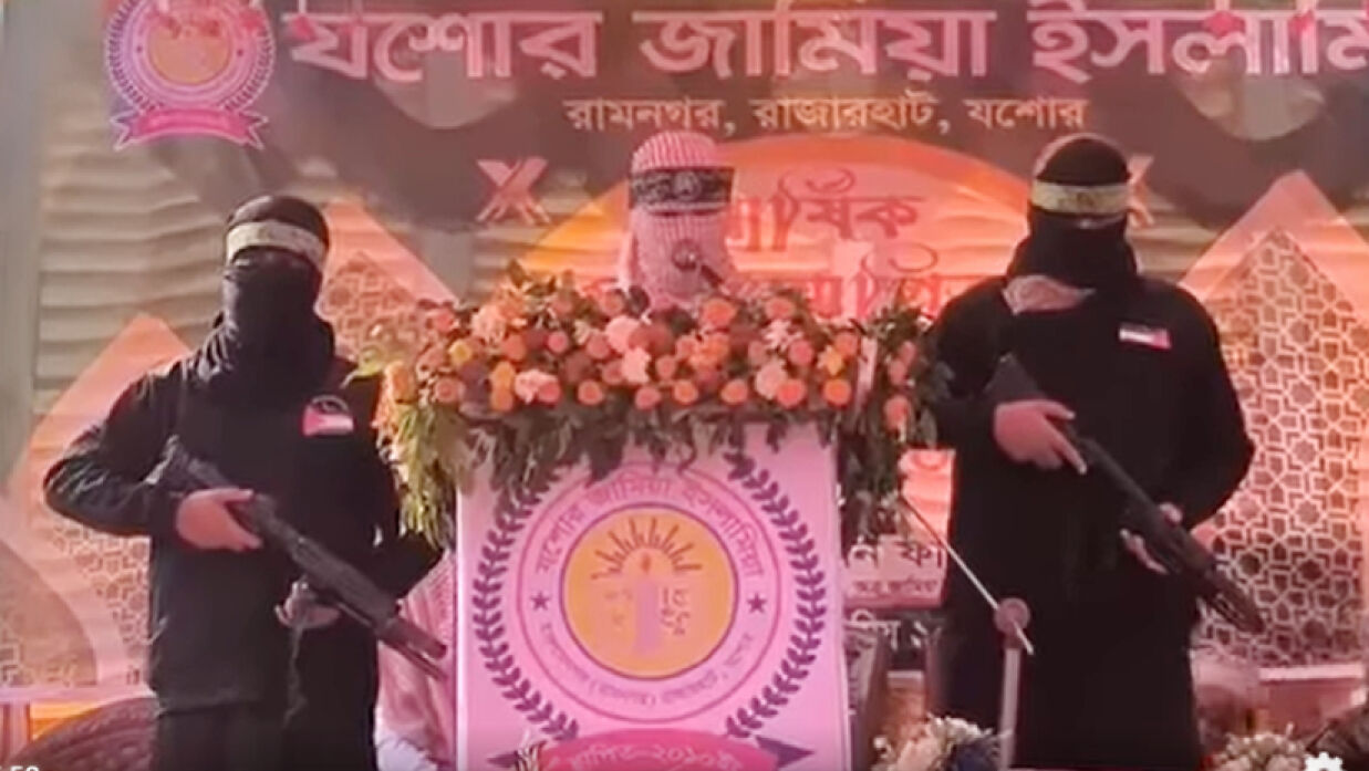 কালো মুখোশ পরিহিত দুই ব্যক্তি অস্ত্রসহ দাঁড়িয়ে আছে