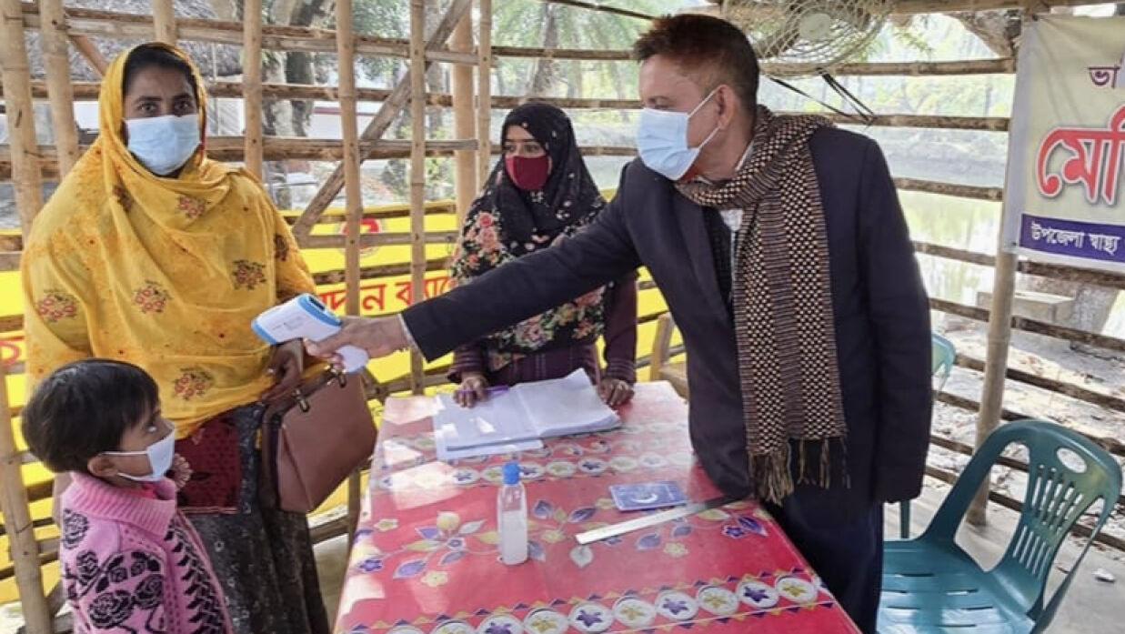 থার্মাল স্ক্যানার দিয়ে যাত্রীদের শরীরের তাপমাত্রা পরীক্ষার করা হচ্ছে