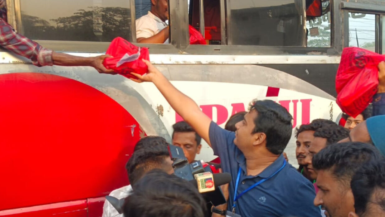 বাসের যাত্রীদের মাঝে ইফতার বিতরণ করছেন নাছির উদ্দীন নাছির।