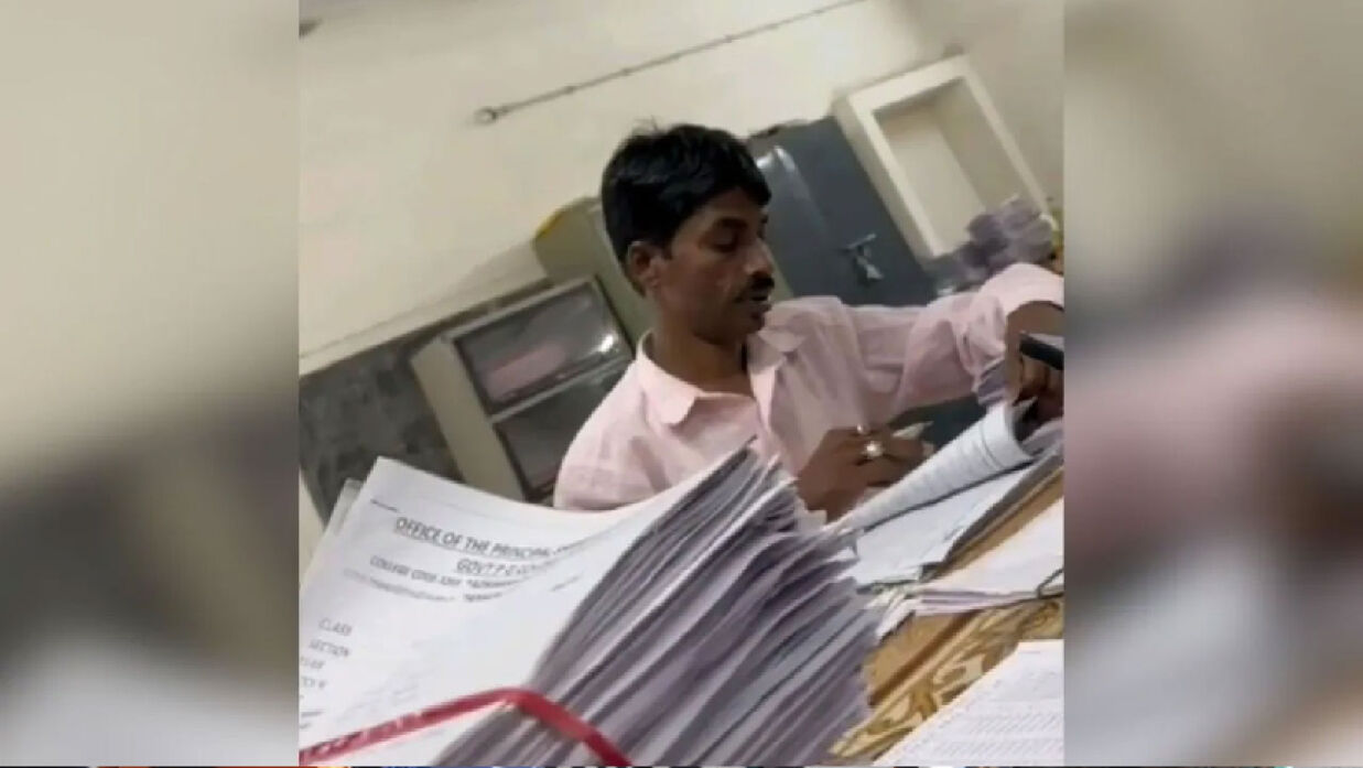 পরীক্ষার খাতা দেখছেন কলেজের পিওন