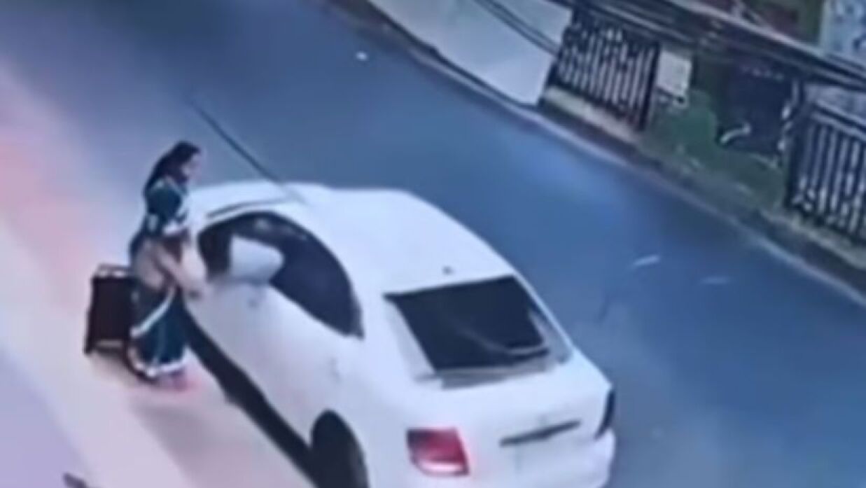 রাস্তার পাশে নিরীহ ভঙ্গিতে দাঁড়িয়ে আছেন এক নারী
