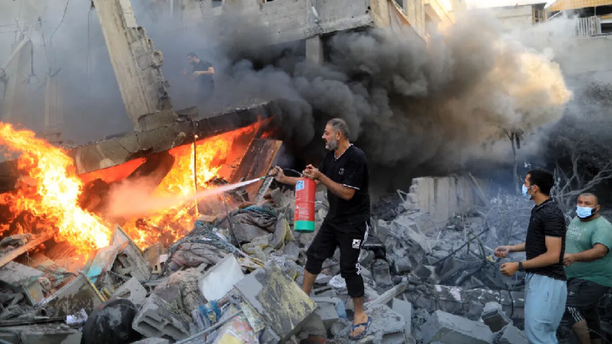 খান ইউনিসে ইসরায়েলি বিমান হামলার পর আগুন নেভানোর চেষ্টা করছেন এক ফিলিস্তিনি