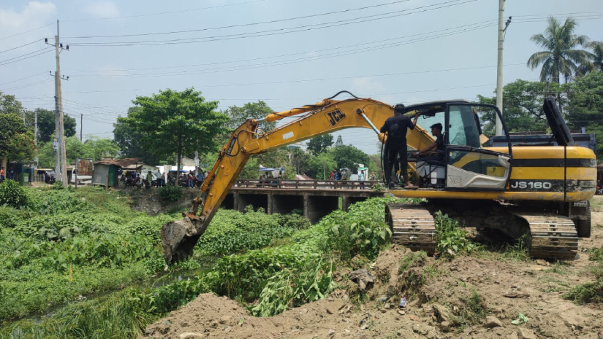 এক্সকাভেটর দিয়ে চলছে ইছামতী নদী খনন কাজ। শনিবার দুপুরে পাবনা শহরের লাইব্রেরি বাজার পুরাতন ব্রিজ এলাকায়